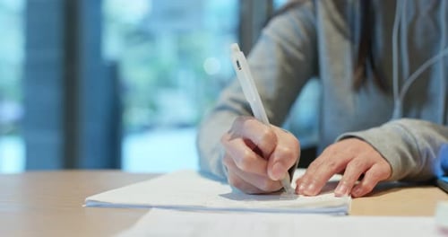Woman study the note on paper at library