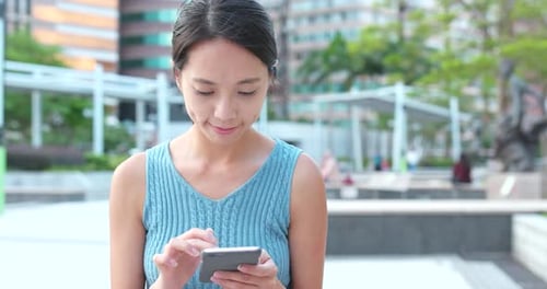 Young Woman use of mobile phone in the park