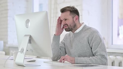 Tired Creative Man Having Headache at Work
