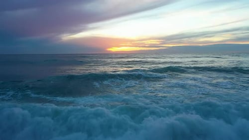 Vagues de mer sur un coucher de soleil lumineux et juteux filmées au-dessus Drone