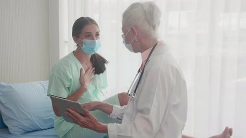 Patient talking with doctor senior feeling worried about disease and lying down at hospital.