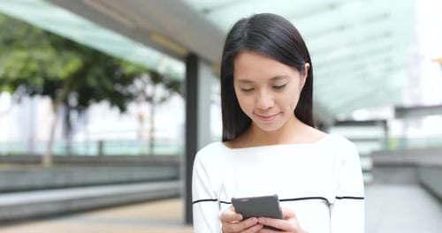 Young Woman Using Smartphone Device in City