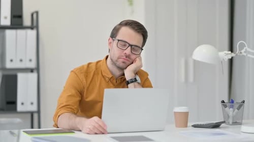 Junger Mann schläft im Büro