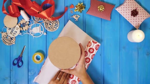 Woman Prepares Round Gift with Wrapping Paper