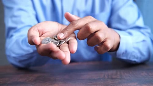 Close Up of Man Hand Counting Coins