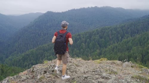 Free man standing on cliff at summit.