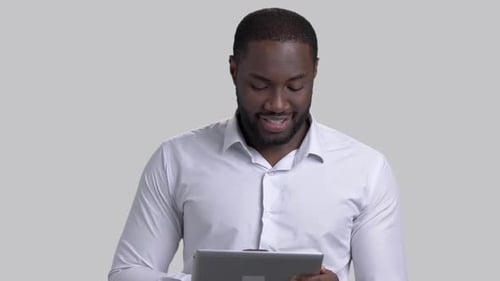 Cheerful Afro-american Businessman Using Electronic Tablet.