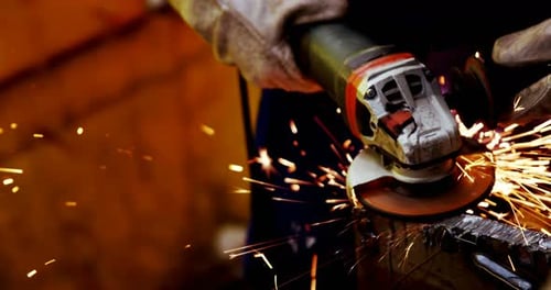 Male engineer using grinder machine in workshop 4k