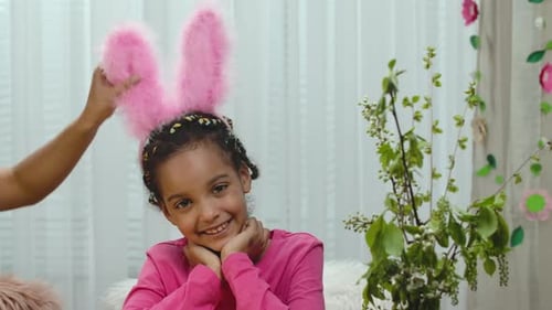 Smiling Child Wearing Bunny Ears is Adjusted