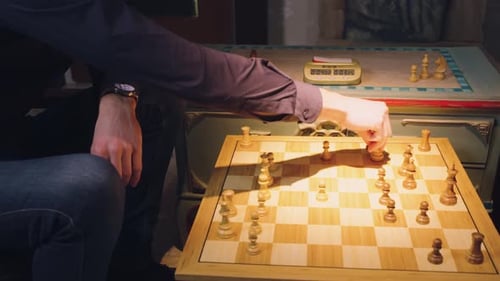 Les mains de deux joueurs d'échecs déplacent les pièces en alternance, retirant quelques pièces d'échecs de l'échiquier b