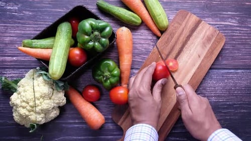 High Angle View of Man Hand Cutting Tomato on Chopping Board