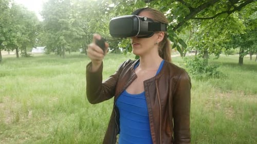 Sexy Woman In A Virtual Reality Helmet Uses A Virtual App In The Park