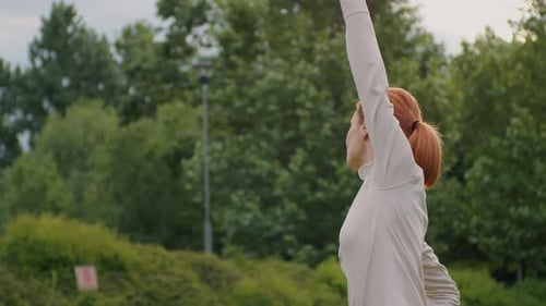 Side view of woman doing stretching outdoor.