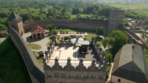 Drone Flies Over Small Medieval Castle on Mountain in Small European City at Sunny Summer Day
