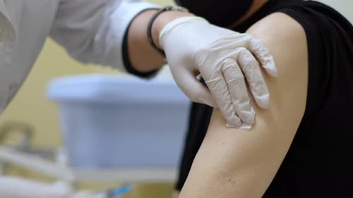 Medical Professional Administers Injection to Patient Arm