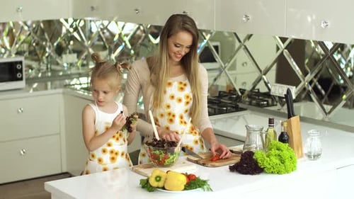 Mother and Daughter Making Healthy Salad in Kitchen