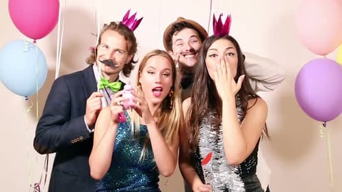 Group of happy friends in party photo booth