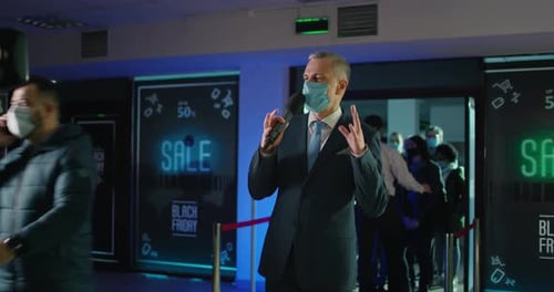Man Speaking at Black Friday Event with Mask