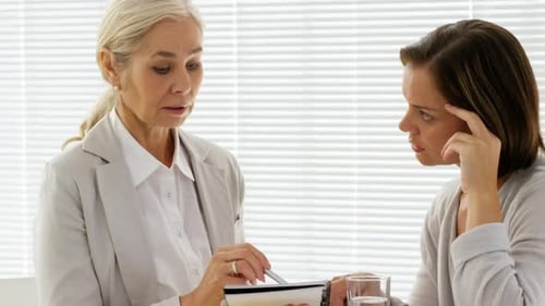 Two Women Speaking in an Office