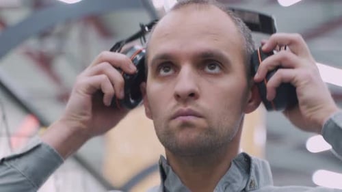 Man Puts on Safety Headphones