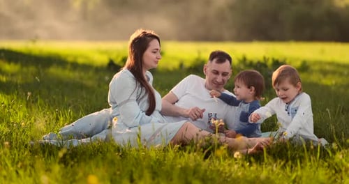 Children Feed Mom on a Picnic Ice Cream Family Lunch Outdoors in the Field in Nature