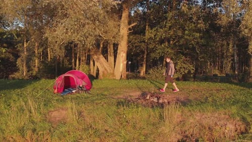 Young Adult Camping in Nature at Sunset