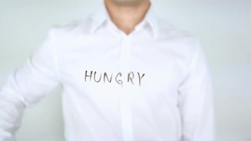 Hungry Written on Glass by Man in White Shirt