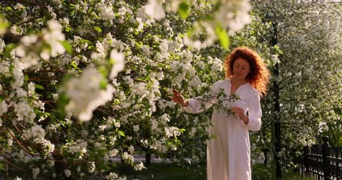 Woman in Blooming Apple Orchard