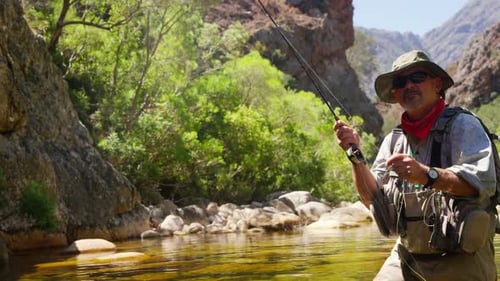 Fisherman fly fishing in river