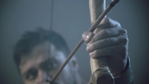 Muskulöser reifer Spartaner Zielen mit Pfeil.
