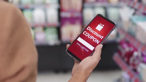 Mulher segurando smartphone com cupom de desconto