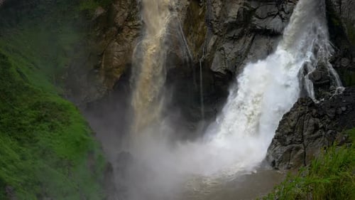 Super Slow motion shot gigantic crashing waterfall in Jungle of Banos,Ecuador