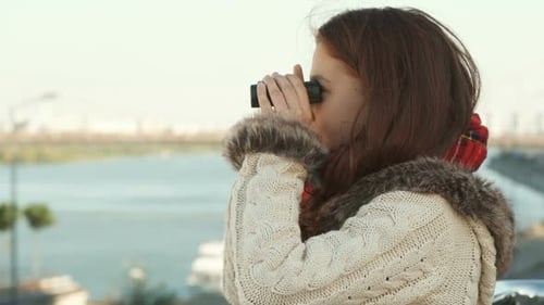 Young Girl Looking Through Binoculars Waving Hand