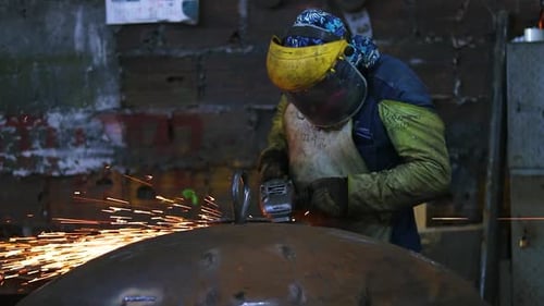 Metal Worker Creates Sparks in Dark Workshop