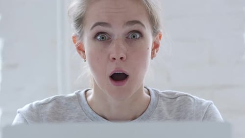Woman Reacts with Surprise at Computer Screen