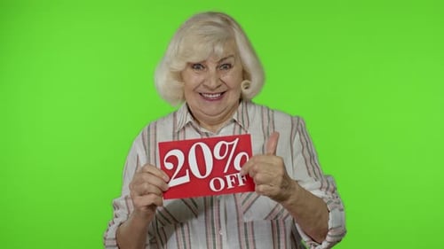Enthusiastic Senior Woman Presents a 20 Percent Discount