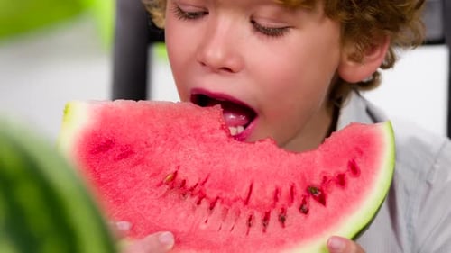 Boy Eats Slice of Juicy Pink Watermelon