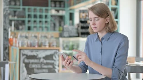 Woman Uses Smartphone and Credit Card Indoors