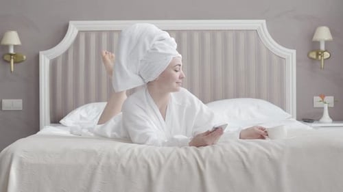 Woman Relaxing on Bed in Robe and Towel