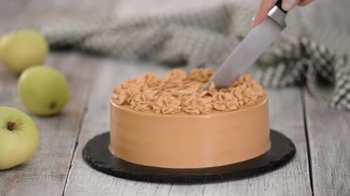 Cutting Decadent Caramel Cake on Wooden Table