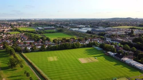 Toma aérea sobrevolando un campo deportivo de la ciudad y un parque recreativo en verano
