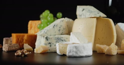 Cheese Assortment with Grapes on Black Background