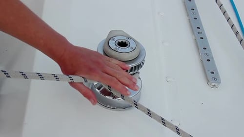 Gros plan mains mâles fixant la corde sur le yacht, se préparant à naviguer