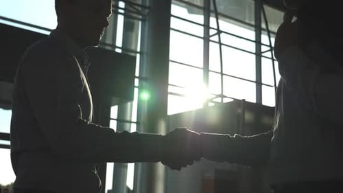 Two Caucasian Businessmen Greeting Each Other in Office. Colleagues Meet and Shake Hands in the City
