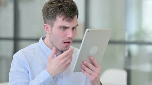 Man Using Tablet Looking Shocked and Upset