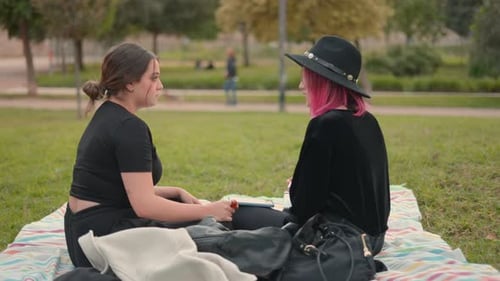 Women Spending Leisure Time and Chatting While Sitting at City Park