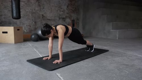 Woman Doing Plank Exercise in Gym