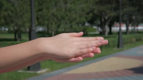 Hands Using Hand Sanitizer in a Park