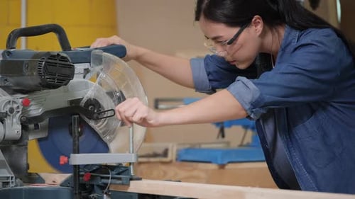 Woman Cuts Wood with Chop Saw in Workshop