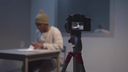 Un témoin examine des documents sous surveillance vidéo